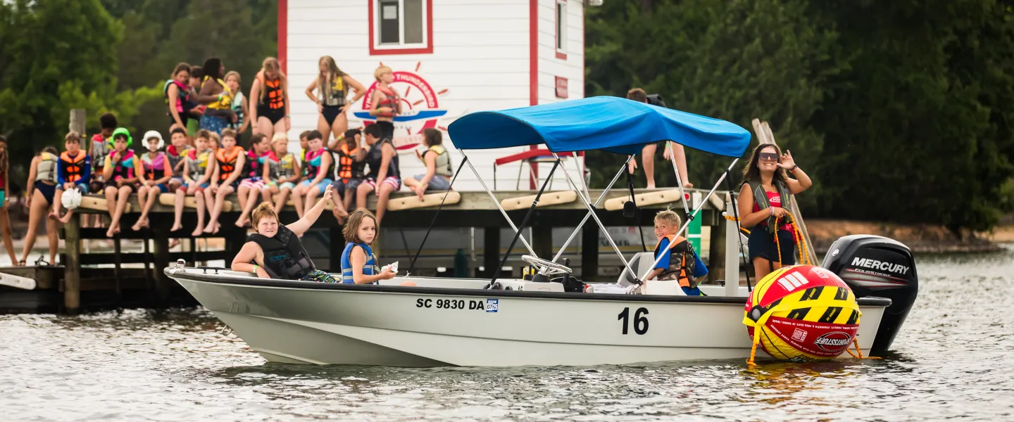 Group of kids on a lake waiting for sailing
