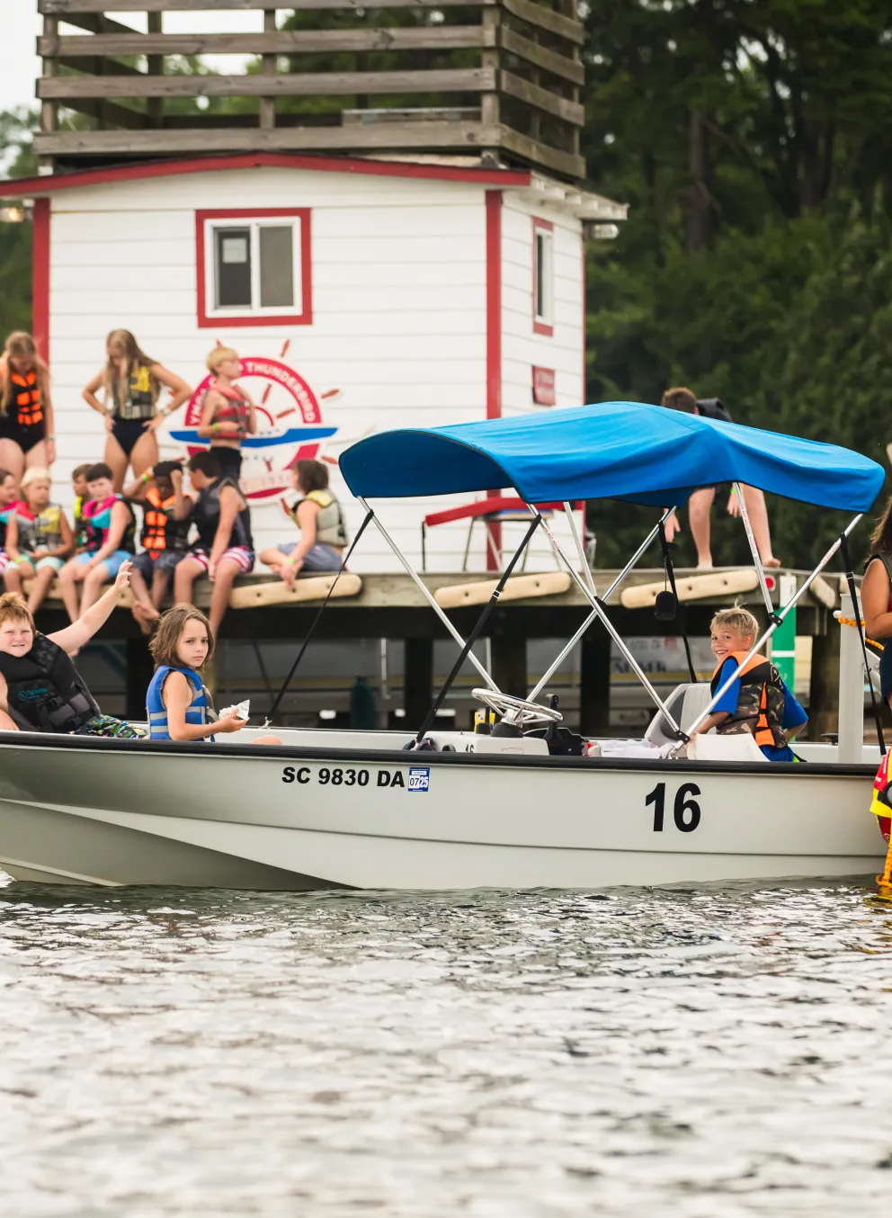 Group of kids on a lake waiting for sailing